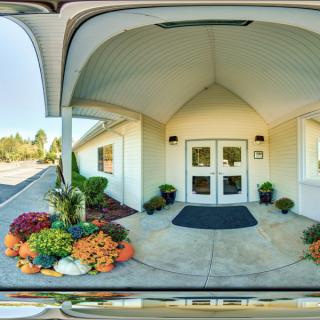 A building entrance featuring decorative plants and flowers.