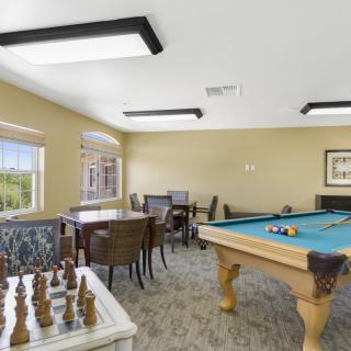 A cozy game room with a pool table and chess set, offering a relaxing space for leisure activities.