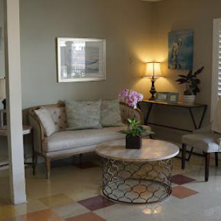 A cozy living room featuring a stylish sofa, a round coffee table with a plant, and soft lighting.