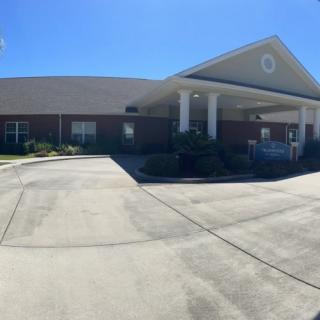 A single-story building with a driveway and clear blue skies.