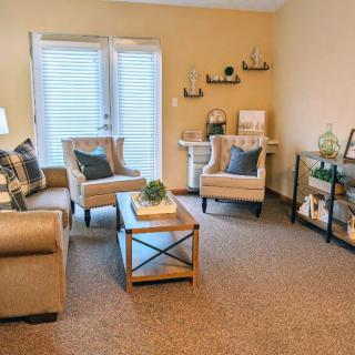 A cozy living room with comfortable seating and decorative shelves.