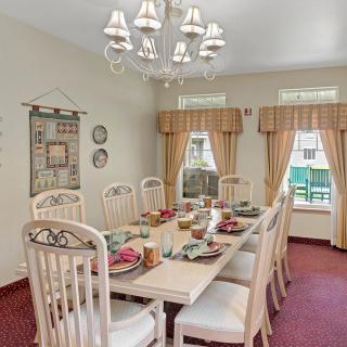 A well-decorated dining room with a long table, elegant chandelier, and tasteful decor.