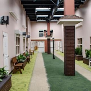 A spacious indoor hallway with benches, plants, and decorative columns.