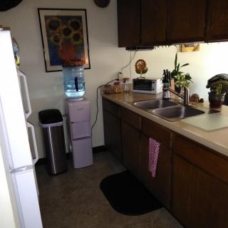 A cozy kitchen with a water dispenser and various appliances.