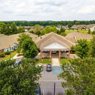 Aerial view of a suburban building with a parking lot surrounded by trees.
