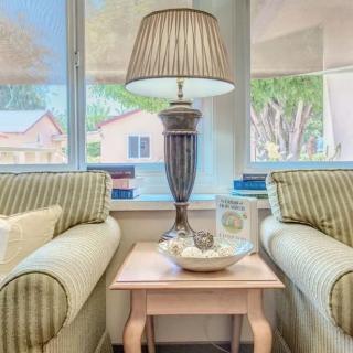 A cozy living room setup with a table lamp between two sofas by the window.