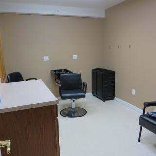 An empty salon room with chairs and hairdressing equipment.