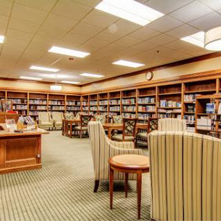 A cozy library setting with shelves full of books and comfortable seating for reading.