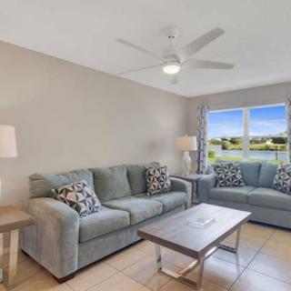 A bright and cozy living room with two sofas, a coffee table, and a view through the window.