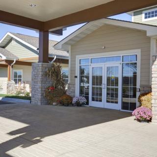 The entrance of a modern building featuring glass doors and landscaping.