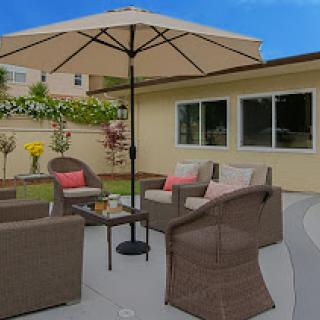 A cozy outdoor seating area with a stylish umbrella and comfortable furniture, perfect for relaxation in the garden.