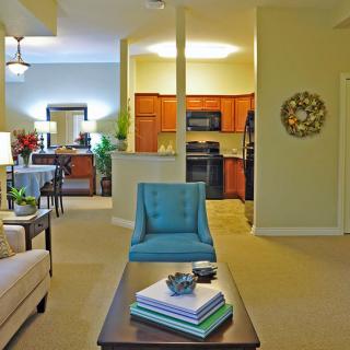 A modern apartment living room with an open layout leading to the kitchen.