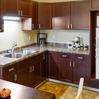 A modern kitchen with dark wood cabinets and stainless steel appliances.