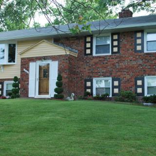 A suburban brick house with a well-maintained lawn.