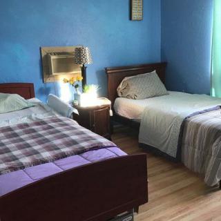 A cozy bedroom with two beds and blue walls.