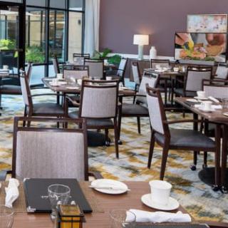 An empty restaurant dining area with neatly set tables and chairs.