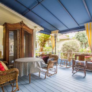 A cozy patio with wicker furniture under a blue canopy.