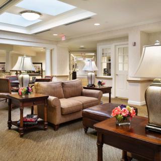 A cozy living room with sofas, tables, and elegant lamps.