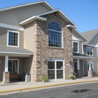 A modern residential building with a stone facade and large windows.