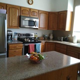A modern kitchen with wooden cabinets and stainless steel appliances.