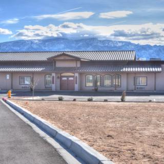 A single-story building with a mountainous backdrop and clear sky.