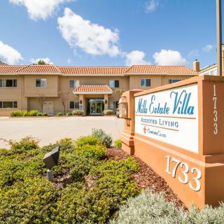 Exterior view of a hotel with clear signage and landscaped surroundings on a sunny day.