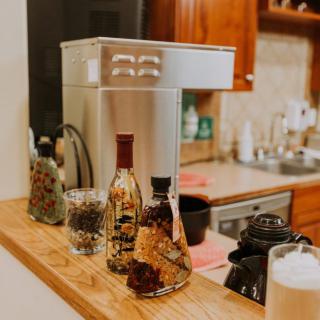 A cozy kitchen counter adorned with decorative bottles and a sleek coffee machine.