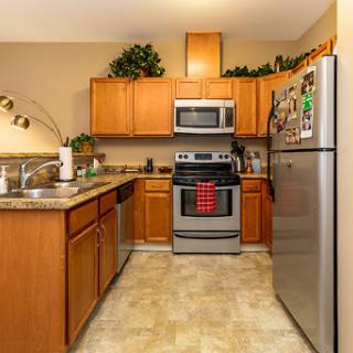 A modern kitchen featuring wooden cabinets, stainless steel appliances, and a well-organized layout.