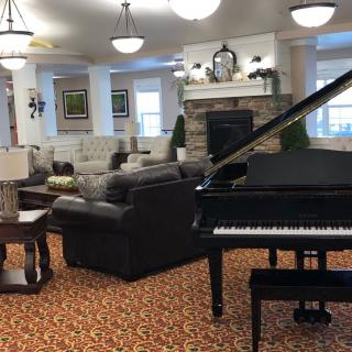 A cozy lounge area featuring a grand piano and elegant furnishings.
