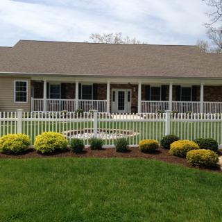 A well-maintained house with a neatly landscaped front yard and a white picket fence.