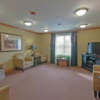 A cozy living room with comfortable seating, a TV unit, and soft lighting.