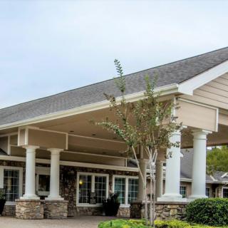 A building entrance featuring tall columns and a peaked roof.