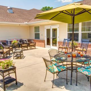 A sunny patio with tables, chairs, and umbrellas for outdoor seating.