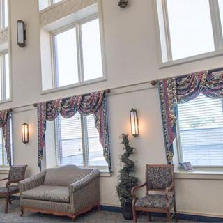 A spacious lobby area with large windows, stylish curtains, and comfortable seating.