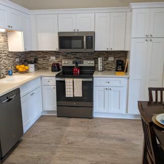 A modern kitchen with white cabinets and stainless steel appliances.