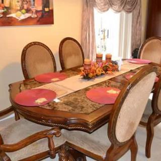 A classic dining room setup with a wooden table, matching chairs, and decorative placemats.