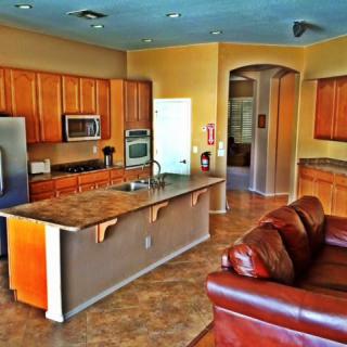 Modern open-concept kitchen and living area with wood cabinets and a central island.