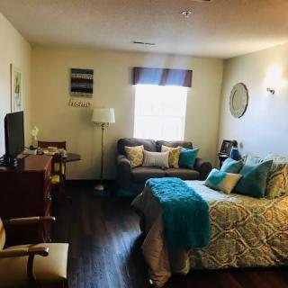 Cozy bedroom with a bed, couch, and television.