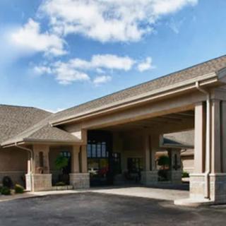 A large building entrance with a covered driveway and clear skies overhead.