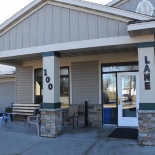 Entrance to a building with stone pillars and outdoor seating.