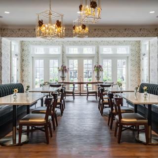 A beautifully designed restaurant dining area with elegant chandeliers and ample natural light.