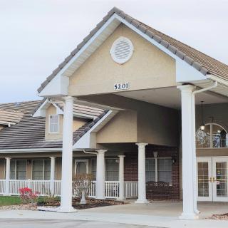 A building entrance with pillars and a triangular roof design.