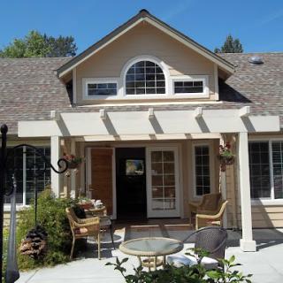 A charming house with a welcoming front porch and well-maintained landscaping.