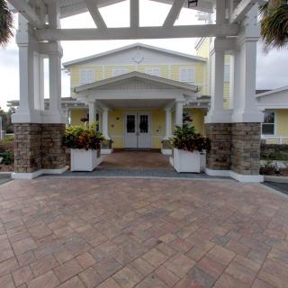 The entrance of a building featuring columns and stonework with planters.