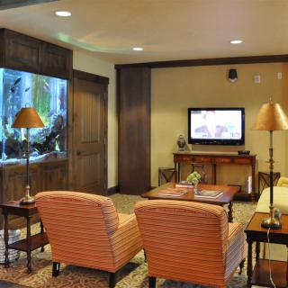 A cozy living room featuring an aquarium and a television with comfortable seating.