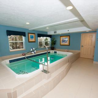 A cozy indoor swimming pool designed for exercise and aquatic therapy, featuring blue walls and well-lit surroundings.