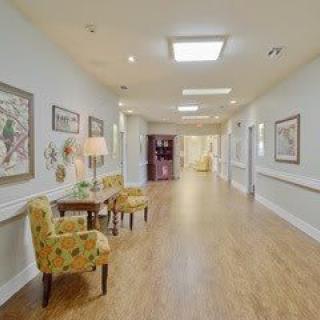 A well-lit hallway with seating and artwork on the walls.