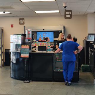 A healthcare reception area where medical staff assist patients.