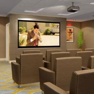 A cozy home theater setup with plush seating and a large projector screen.