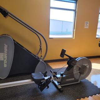 A rowing machine positioned in a well-lit gym, perfect for full-body workouts.